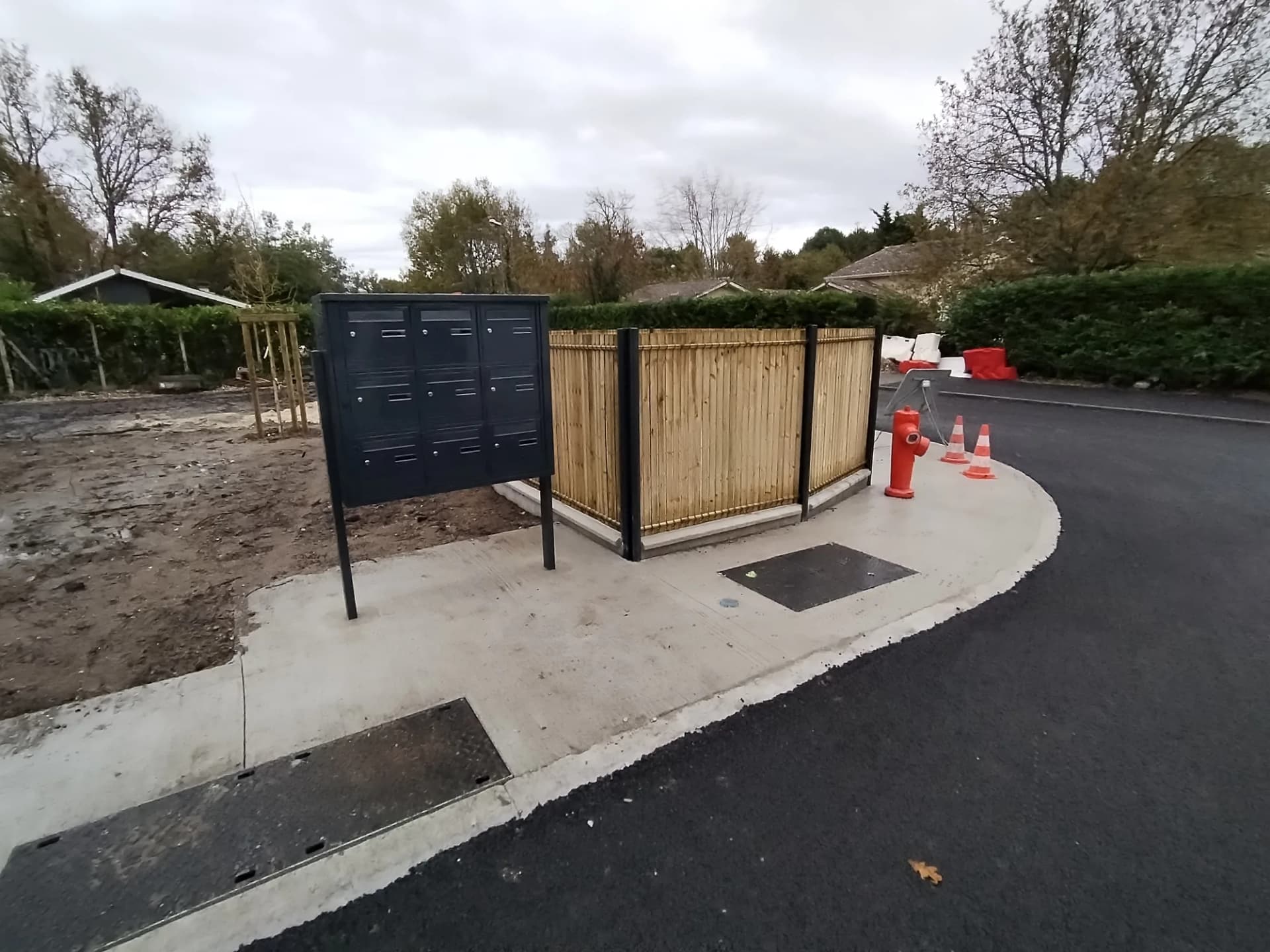 Espace extérieur avec boîte aux lettres et point d'eau.