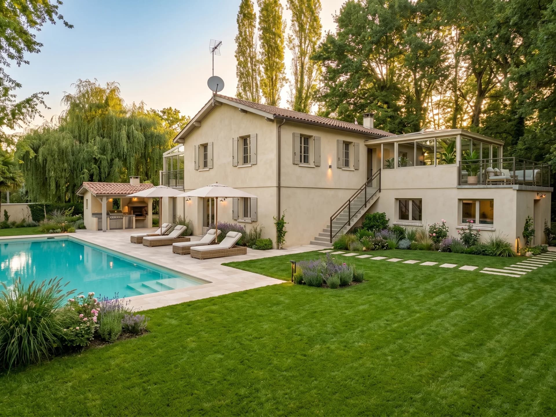 Villa avec piscine, jardin paysager et terrasse ensoleillée.