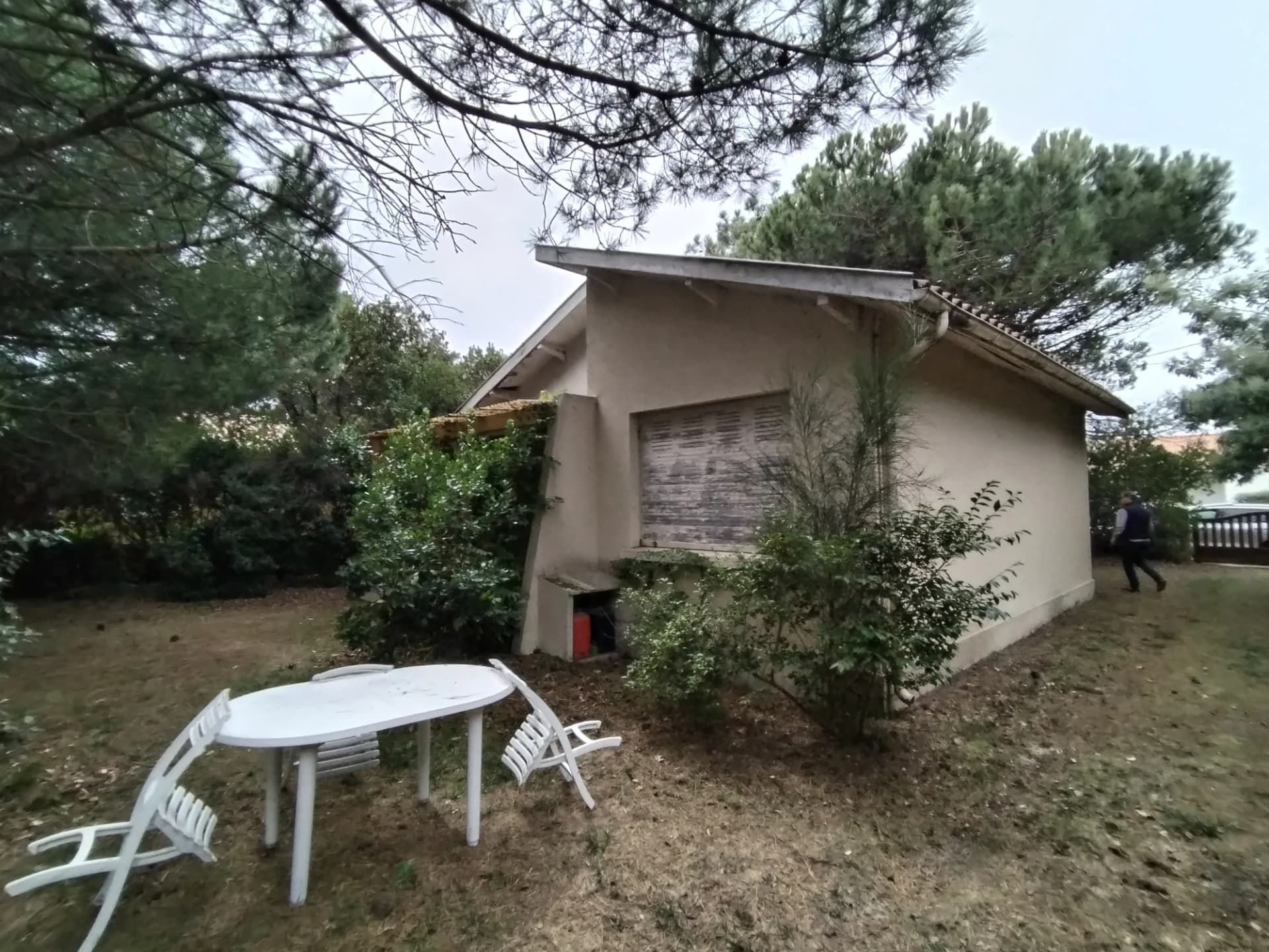Maison de plain-pied avec jardin et mobilier de terrasse.